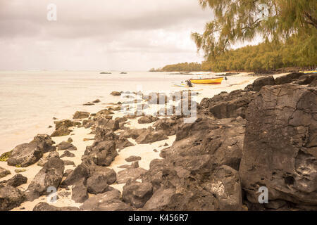 Boats lie on rocky beach in Mauritius Stock Photo