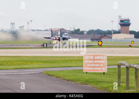 A USAF F-15E Strike Eagle from the 494th Fighter Squadron powers down the runway using its afterburners to take off. Stock Photo