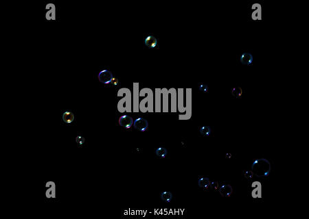 Rainbow soap bubbles on a dark background. Stock Photo