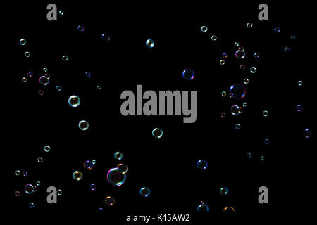 Rainbow soap bubbles on a dark background. Stock Photo