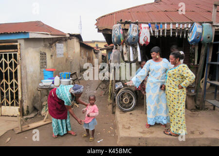 Nigerian woman and girl in front of spare parts in the city of Akure, capital of Ondo State in Nigeria Stock Photo