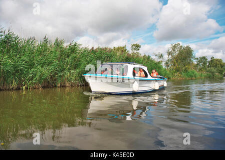 Day out on the Norfolk Broads with a Day hire boat on the River Ant near How Hill with a family wearing life jackets Stock Photo