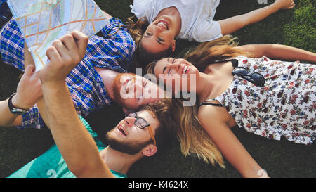 Young tourists resting on grass while traveling Stock Photo