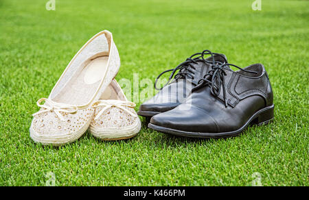 Women's and men's wedding shoes on the green grass. Symbol of love. Stock Photo