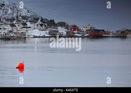 NE-wards view at sunset over Reinevagen-bay of Reinefjorden to the fishing port in Andoya-island and the fishing boats moored on the pier. Big red flo Stock Photo