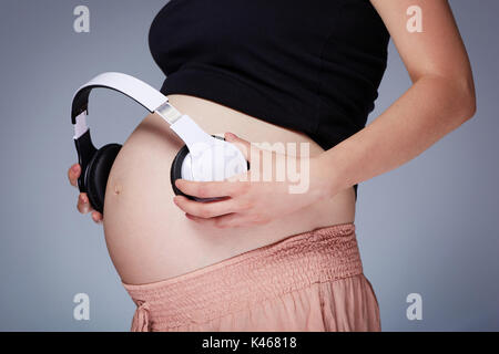 Pregnant woman and headphones on tummy Stock Photo by ©Syda_Productions  67173253