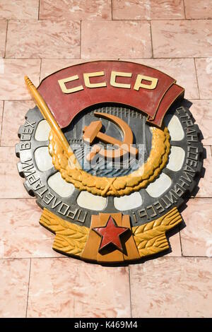 Retro mosaic Soviet CCCP emblem with hammer and sickle hanging on a rock wall in Moscow, Russia Stock Photo