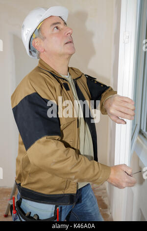 worker in coverall near pvc window frames at factory Stock Photo