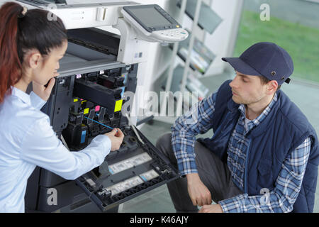 engineer and worker trying to repair the office printer Stock Photo