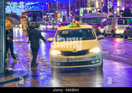 Man taking a taxi on rainy day at Gran Via street. Madrid. Community of Madrid. Spain Stock Photo