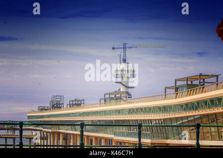 The pier of Scheveningen in the Netherlandsan a sunny day with blue sky in the background. Stock Photo