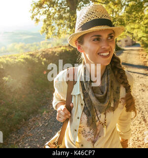 Discovering magical views of Tuscany. happy adventure woman hiker with bag on Tuscany hike Stock Photo