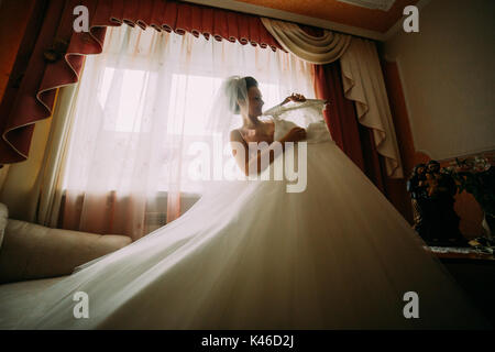 Young beautiful woman, pretty bride ready to dress wedding gown Stock Photo