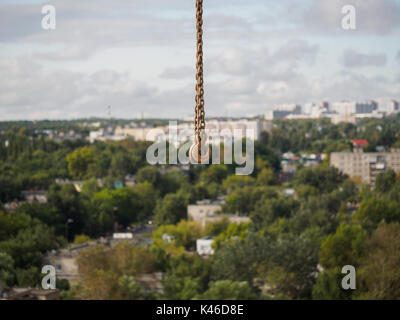 small rusty crane hook on background city view Stock Photo