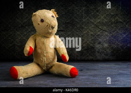Old threadbare and dishevelled teddy bear doll. Stock Photo