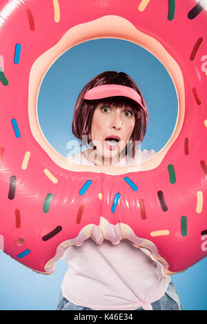 Stylish senior woman in casual clothes and sunglasses gesturing horns ...