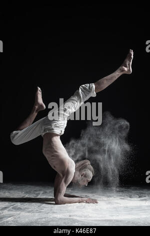 Flexible yoga man doing hand balance asana vrischikasana. Stock Photo