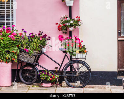 An old delivery bike used as a plant stand outside a house in Dunster High Street, Somerset.