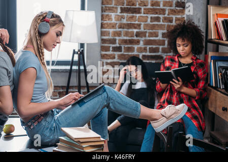 multiethnic group of students studying together with books and digital tablet Stock Photo