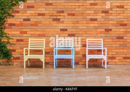 Red brick wall with chairs and ornamental Stock Photo