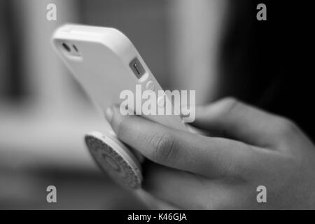 Black & White Close up of Young Girl Playing on iPhone Stock Photo