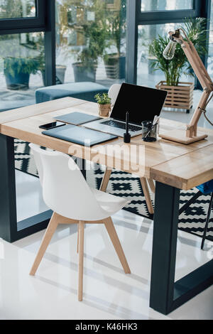 Laptop with blank screen, graphic tablet and smartphone on table in modern office Stock Photo