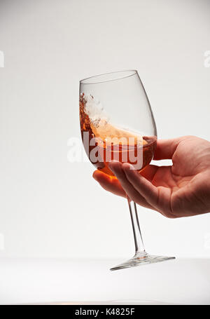 Holding red wine in glass and shake for tasting. Check quality of red wine Stock Photo