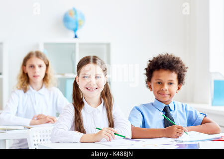 Kids by desks Stock Photo