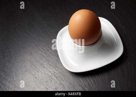 Closeup of a brown egg on a table slate. Stock Photo