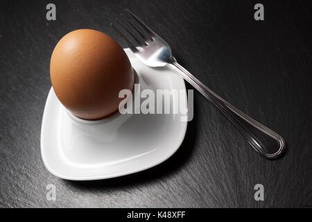 Closeup of a brown egg on a table slate. Stock Photo
