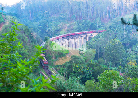 The early morning on the mountain slope with a view on the train, running along the Nine Arches Bridge, Demodara, Ella, Sri Lanka. Stock Photo