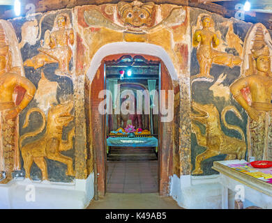 BATTALA, SRI LANKA - DECEMBER 2, 2016: The facade wall of the image house of Yudaganawa temple is decorated with Dragon Arch, sculptures of lions and  Stock Photo