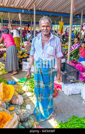 WELLAWAYA, SRI LANKA - DECEMBER 2, 2016: The market vendor poses for photo in his stall in local food market, on December 2 in Wellawaya. Stock Photo