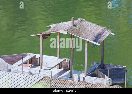 Bootssteg mit einfachen Bootshaus oder Holzboot mit Strohdach. Stock Photo