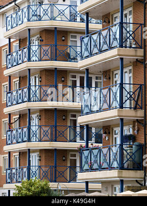 Modern flats and apartments with blue painted metal railings and balconies, Sovereign Harbour, Eastbourne, East Sussex, England, UK. Stock Photo