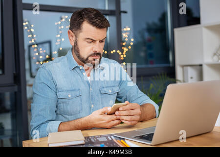 Serious troubled man checking his messages Stock Photo
