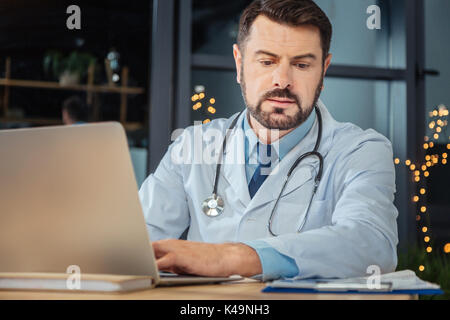 Serious hard working scientist using a laptop Stock Photo