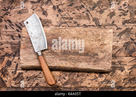 Vintage Meat cleaver and cutting board on old wooden background Stock Photo