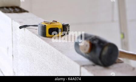 Work tools put on a autoclaved aerated concrete blocks wall. Stock Photo