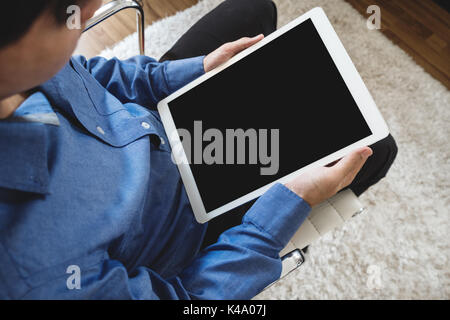 a man using digital tablet computer, sitting on modern chair, clipping path empty black vertical screen Stock Photo