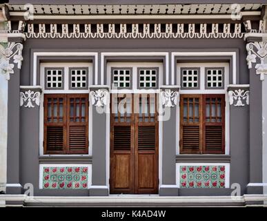 Traditional heritage Singapore shop house with striking white and gray exterior and brown wooden shutters in historic Little India. Stock Photo