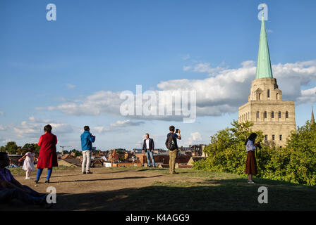 Oxford, UK. Tourists on the Castle Mound admiring the view of the tower of Nuffield College (1949) Stock Photo
