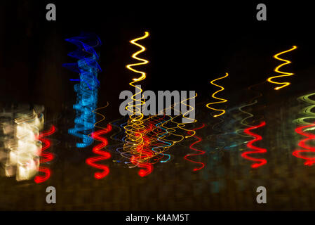 Colored lights in motion of spiral at night on street as abstract background Stock Photo