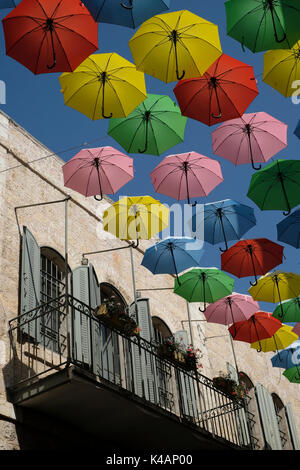 Colorful umbrellas are suspended above Nahalat Shiva alley a pedestrian promenade in West Jerusalem Israel Stock Photo