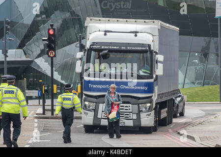 London, UK. 5th Sep, 2017. Police walk towards a woman walking slowly holding a Quaker peace banner in front of a lorry going towards the West gate taking exhibits into the world's largest arms fair held in London's docklands on the 'No Faith in War' day of protests organised by various faith groups. Before I arrived there had been a lock-in on the approach road stopping deliveries coming to set up the fair through the East gate. Credit: Peter Marshall/Ģ����ý Live News Stock Photo