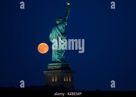Jersey City, USA. 5th Sep, 2017. Full moon is seen near the Statue of Liberty in Jersey City in the United States on the evening of this Tuesday, September 05.