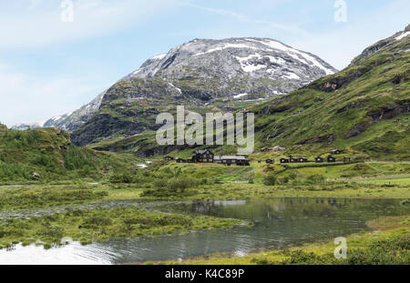 houses in nature area Jostedalsbreen in summer with snow on the mountains Stock Photo