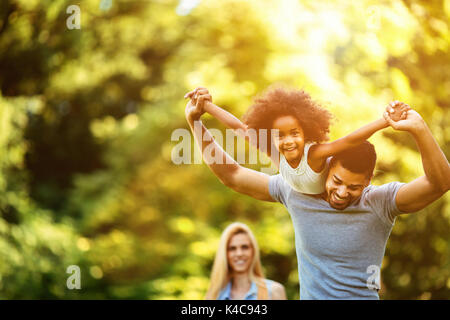 Portrait of young father carrying his daughter on his back Stock Photo