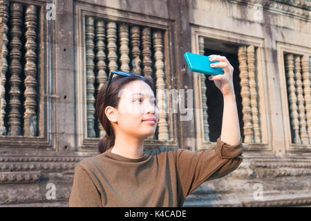 Female traveler selfie with her smartphone in angkor wat siem reap cambodia Stock Photo