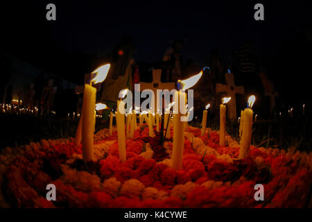 Family members light candles and put them on the graves of their loved ones during All Souls' Day on November 02 at Holy Rosary Catholic Church in Dha Stock Photo